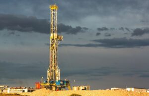 A Rodatherm Power deseja tornar a geotérmica mais confiável; no entanto, será mais acessível? A rig drills into the earth against a cloudy sky.