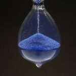 A Apple diz que a lei da UE significa que mais recursos estão atrasados, talvez até um novo hardware | Foto de close-up de ampulheta com areia azul