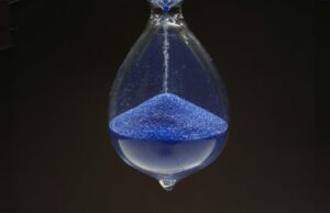 A legislação da Apple States da UE certamente sugerirá que muito mais funções são adiadas, talvez até novos equipamentos novos A Apple diz que a lei da UE significa que mais recursos estão atrasados, talvez até um novo hardware | Foto de close-up de ampulheta com areia azul