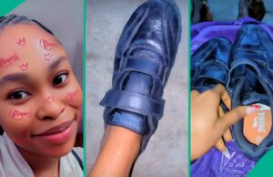 A senhora nigeriana mostra um presente de sapato do palco, as pessoas não param de falar A senhora nigeriana mostra um presente de sapato do palco, as pessoas não param de falar