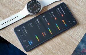 A Samsung Health finalmente está levando os treinos a sério Um telefone na mão exibindo a tela inicial do aplicativo Samsung Health com arbustos em segundo plano