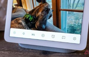 Alguns clientes cientes do Nest obtêm 50% de corte de preços de renascimento do Google O alto -falante do Nest Audio com suas luzes ativas, sentado em uma pequena pilha de livros