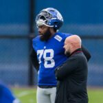 O ataque ofensivo do New York Giants, Andrew Thomas, falando com o técnico Brian Daboll.