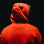 Apple sob escrutínio legal na UE Over Scam Apps | Rosto escondido por capuz e escuridão