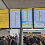 This photograph shows passengers waiting next to a flight information board of the Brussels Airport in Brussels on September 20, 2025, after the airport's system was hit by a "cyberattack" overnight on September 19.