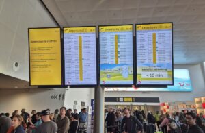 Apreensão das autoridades do Reino This photograph shows passengers waiting next to a flight information board of the Brussels Airport in Brussels on September 20, 2025, after the airport's system was hit by a "cyberattack" overnight on September 19.