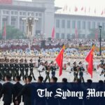 O líder norte-coreano Kim Jong-un, centro, é recebido pelo ministro das Relações Exteriores chinês Wang Yi em sua chegada a uma estação de trem em Pequim.