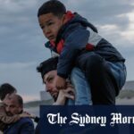 As famílias de migrantes entram no mar em Gravelines, na França, na tentativa de embarcar em um pequeno barco indo para o Reino Unido.
