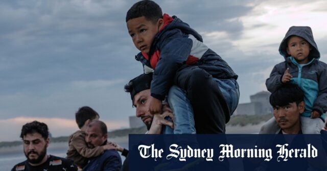 As famílias de migrantes entram no mar em Gravelines, na França, na tentativa de embarcar em um pequeno barco indo para o Reino Unido.