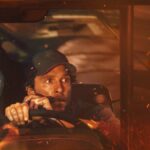 Willem Dafoe e Corey Hawkins Clink Drinks em um quarto escuro