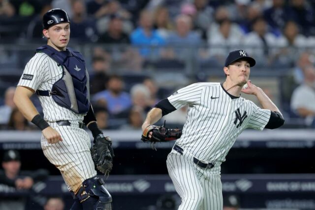 O arremessador inicial do New York Yankees, Max Fried, lance para a primeira base, enquanto o apanhador Ben Rice olha.