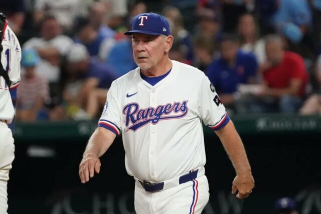 O gerente do Texas Rangers, Bruce Bochy, caminha até o monte para uma mudança de arremesso.