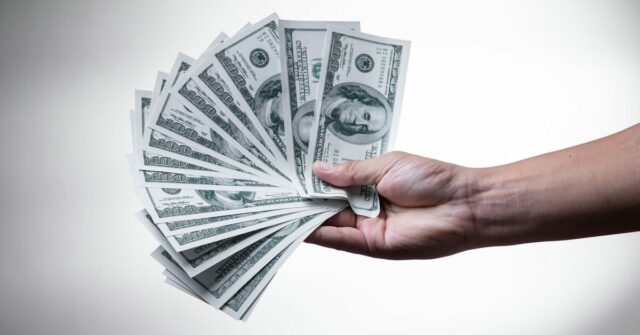 Com três novos lançamentos futuros, os produtos da Apple aumentarão os preços mais altos do que nunca | Mão segurando um monte de notas de US $ 100