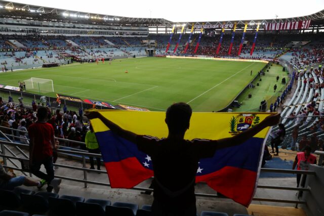 Os fãs da Colômbia posam com bandeira gigante no estádio de futebol