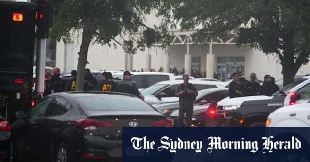 O corpo do suspeito de tiro é colocado na van dos exames médicos.