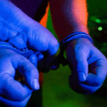 Duas mãos em algemas policiais.
