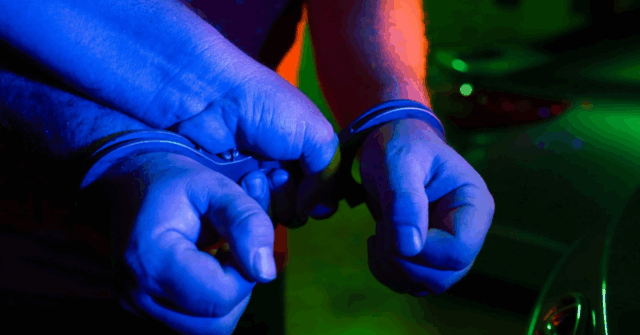 Duas mãos em algemas policiais.