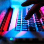 Man typing at his laptop computer at night