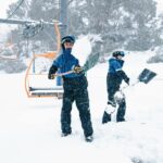 Os esquiadores trabalham para limpar a neve froma cidrelift em Falls Creek, Victoria.