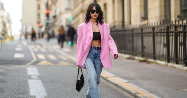 Alba Garavito Torre wears black sunglasses from Ray Ban, gold and white pendant large earrings, a black t-shirt, a white with black small striped print pattern wool pullover from Massimo Dutti, a black shiny grained leather Timeless shoulder bag from Chanel, a black oversized blazer jacket from Munthe, white skinny denim pants from Zara, beige shiny leather with black toe-cap ballerinas from Chanel , during a street Estilo de sessão de fotos de moda, em 29 de abril de 2023 em Paris, França.