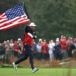Keegan Bradley corre com a bandeira americana durante uma rodada de treinos da Ryder Cup em Bethpage Black em 25 de setembro de 2025.