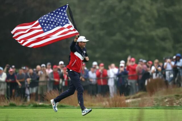 Keegan Bradley corre com a bandeira americana durante uma rodada de treinos da Ryder Cup em Bethpage Black em 25 de setembro de 2025.