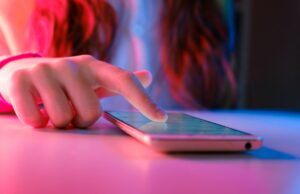 Um órgão de fiscalização do consumidor emitiu um aviso sobre o protocolo de compras do agente de IA do Google – o Google diz que ela está errada person touching a smartphone laying on a table.