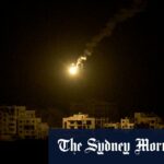 Um flare do exército israelense se aproxima dos edifícios destruídos durante as operações terrestres e aéreas israelenses na faixa do norte de Gaza.