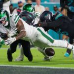 O New York Jets correndo Braelon Allen (0) atrapalha a bola contra o defensivo de Miami Dolphins, Elijah Campbell (22).