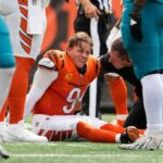O quarterback do Cincinnati Bengals, Joe Burrow, faz uma careta depois de ser demitido pelo ataque defensivo de Jacksonville Jaguars Arik Armstead.