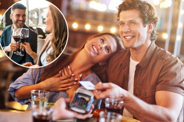 Um casal sorridente em uma data de café, pagando com um cartão de crédito em um terminal.