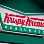 The Krispy Kreme corporate logo is displayed on a sign at their store on January 31, 2025 in San Diego, California