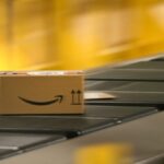 Um pacote com o logotipo da Amazon é transportado ao longo de uma correia transportadora em uma estação de embalagem de um centro de redistribuição da gigante do varejo on-line Amazon em Horn-Bad Meinberg, na Alemanha Ocidental, em 9 de dezembro de 2024.