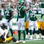 O New York Jets Cornerback Soluce Gardner (#1) fica sobre um jogador do Pittsburgh Steelers em campo.