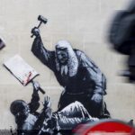 Uma foto divulgada por Banksy da nova obra de arte do artista, que retrata um juiz batendo um manifestante com um martelo no Royal Courts of Justice, em Londres.