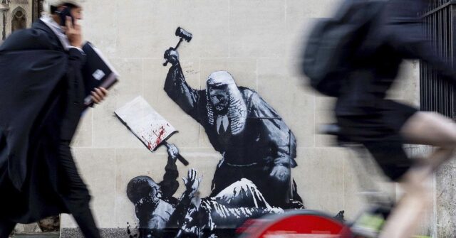 Uma foto divulgada por Banksy da nova obra de arte do artista, que retrata um juiz batendo um manifestante com um martelo no Royal Courts of Justice, em Londres. 