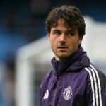 Altay Bayindir em Man Utd Shirt, enquanto o jogador da cidade celebra em segundo plano