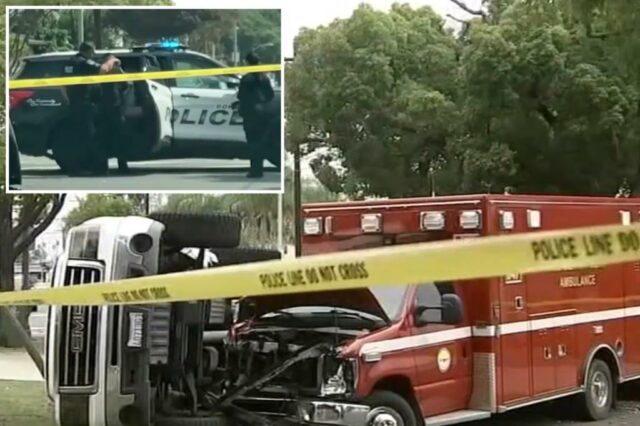 Um caminhão destruído e ambulância em uma cena de acidente, atrás da fita da polícia.