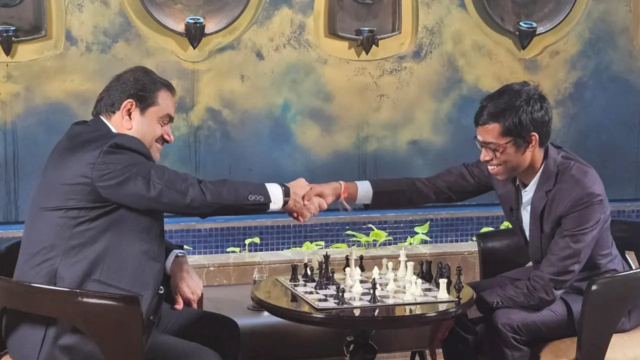 O mestre de xadrez indiano R Praggnanandhaa cumpre o magnata Gautam Adani 

