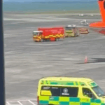 Caminhões de bombeiros e ambulâncias no asfalto do aeroporto de Auckland.