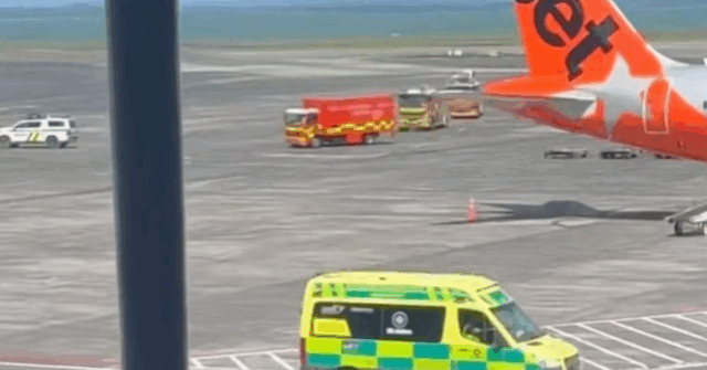 Caminhões de bombeiros e ambulâncias no asfalto do aeroporto de Auckland. 