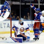 Brennan Othmann (Centro) comemora após um gol de Vincent Trocheck (não fotografado) durante a derrota por 5-4 da pré-temporada dos Rangers para os ilhéus. Othmann marcou um gol próprio no final do período.
