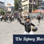 Um manifestante cai durante os confrontos com a polícia de Riot em Katmandu.