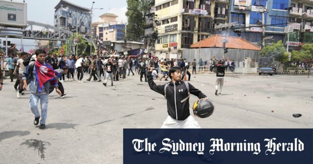 Um manifestante cai durante os confrontos com a polícia de Riot em Katmandu.