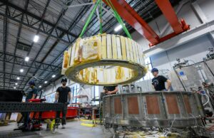 Republic Blend Solution Publications Uma oferta de energia de US $ 1b+ para seu futuro ativador combinado Engineers watch as a magnet is moved inside Commonwealth Fusion System's building.