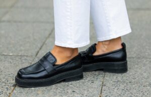 Solta os sapatos: 16 apartamentos e mocassins chiques para usar quando o outono chega perto de Jill Asemota vista usando óculos de sol vintage pretos, Dorothee Schumacher Vestido de malha de lã cinza, jaqueta cardigã de malha de lã cinza da Dorothee Schumacher, meias de algodão branco, tênis de samba de couro branco adidas, em 04 de novembro de 2023 em Berlim, Alemanha.