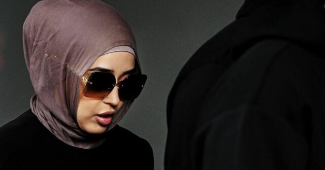 A ex -enfermeira de Saúde de Gales do Sul, Sarah Abu Lebdeh, chega cercada por apoiadores na quadra local do Downing Center, em Sydney.