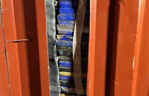 Trabalhadores presos após a polícia abrir um parede falsa no contêiner de remessa Trabalhadores presos após a polícia abrir um parede falsa no contêiner de remessa