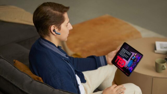 Quatro pessoas bebendo coquetéis e conversando enquanto dois usam fones de ouvido do interprecador de Timekettle AI.