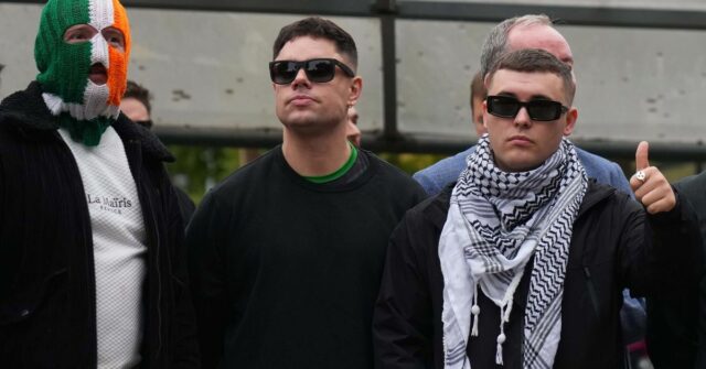 Liam Óg Ó hAnnaidh, aka Mo Chara, right, a member of the Irish language band Kneecap, celebrates as he leaves Woolwich Crown Court in London, Friday, Sept. 26, 2025, after Chief Magistrate, Senior District Judge Paul Goldspring, dismissed a terrorism offence relating to displaying a flag in support of Hezbollah during a performance with the band in November 2024, on a technical error. 